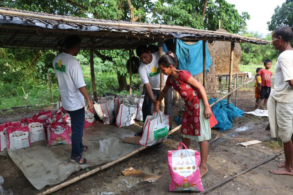Smile’s disaster response team distributing relief material to affected families in Assam